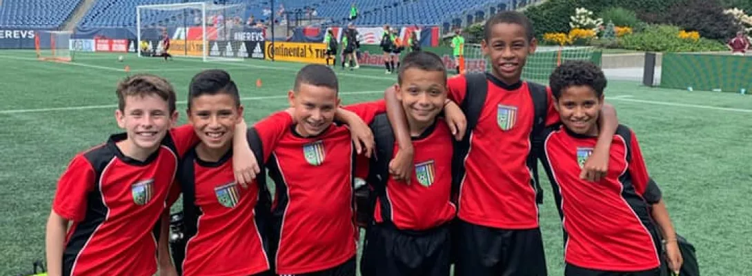Boys youth soccer team posing together on the field