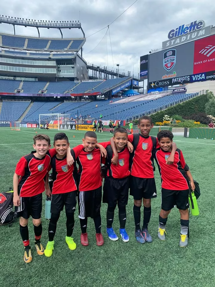 Boys youth soccer team posing together on the field